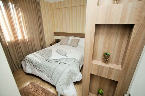 Cozy bedroom with a gray blanket on a white bed