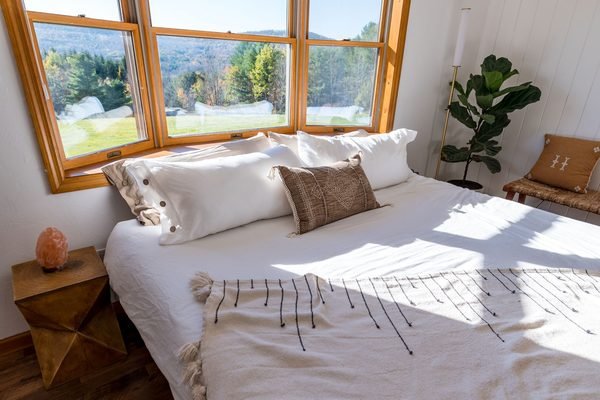 Sunny bedroom with white bedding and a large window