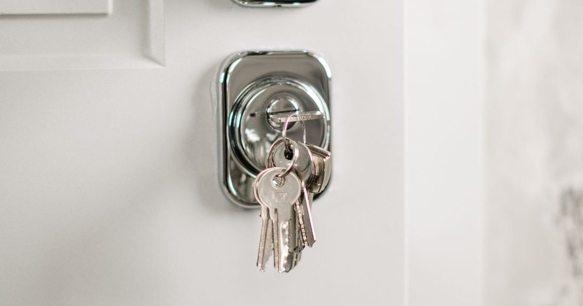 Keys in the lock of a white front door