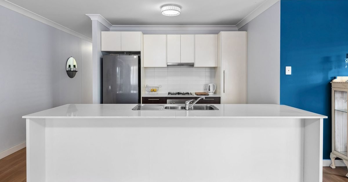 White kitchen counter with sink and cabinets