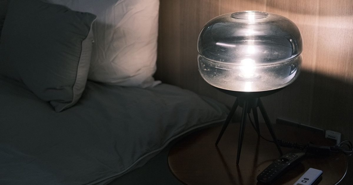Cozy bedroom at night with a glowing table lamp
