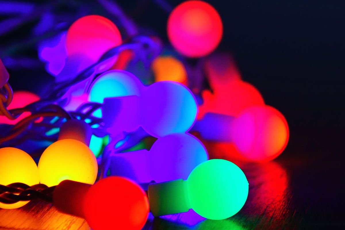 Close-up of large round multicolor light bulbs glowing on a string (representative photo, not the exact product)