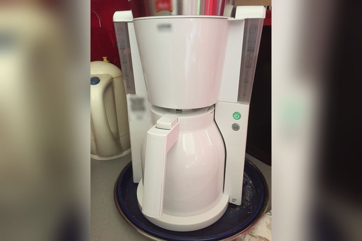 Compact white drip coffee maker with an insulated thermal jug on a kitchen counter (representative photo, not the exact product)