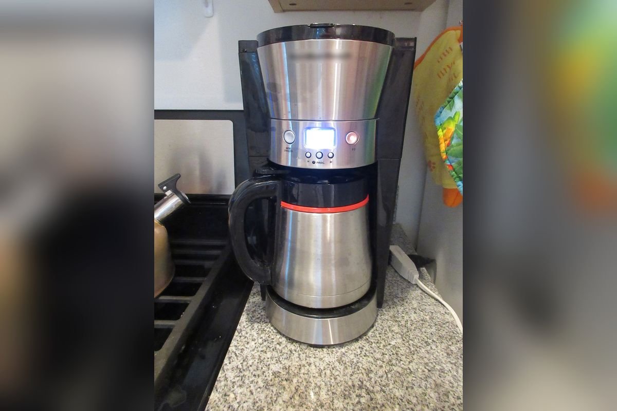Tall stainless steel programmable drip coffee maker with a thermal carafe on a granite counter (representative photo, not the exact product)