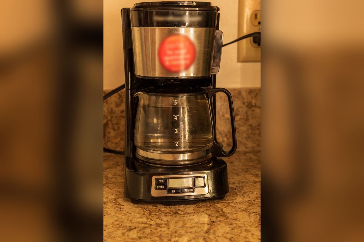 Black and stainless programmable drip coffee maker with a glass carafe on a granite counter (representative photo, not the exact product)