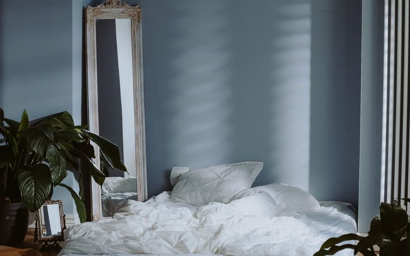 Minimal bedroom with white bedding and plants
