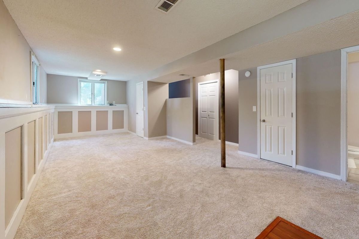 Bright, clean finished basement with carpet and recessed lighting