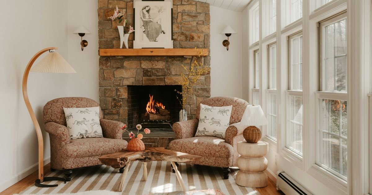 Cozy living room with two armchairs in front of a glowing stone fireplace