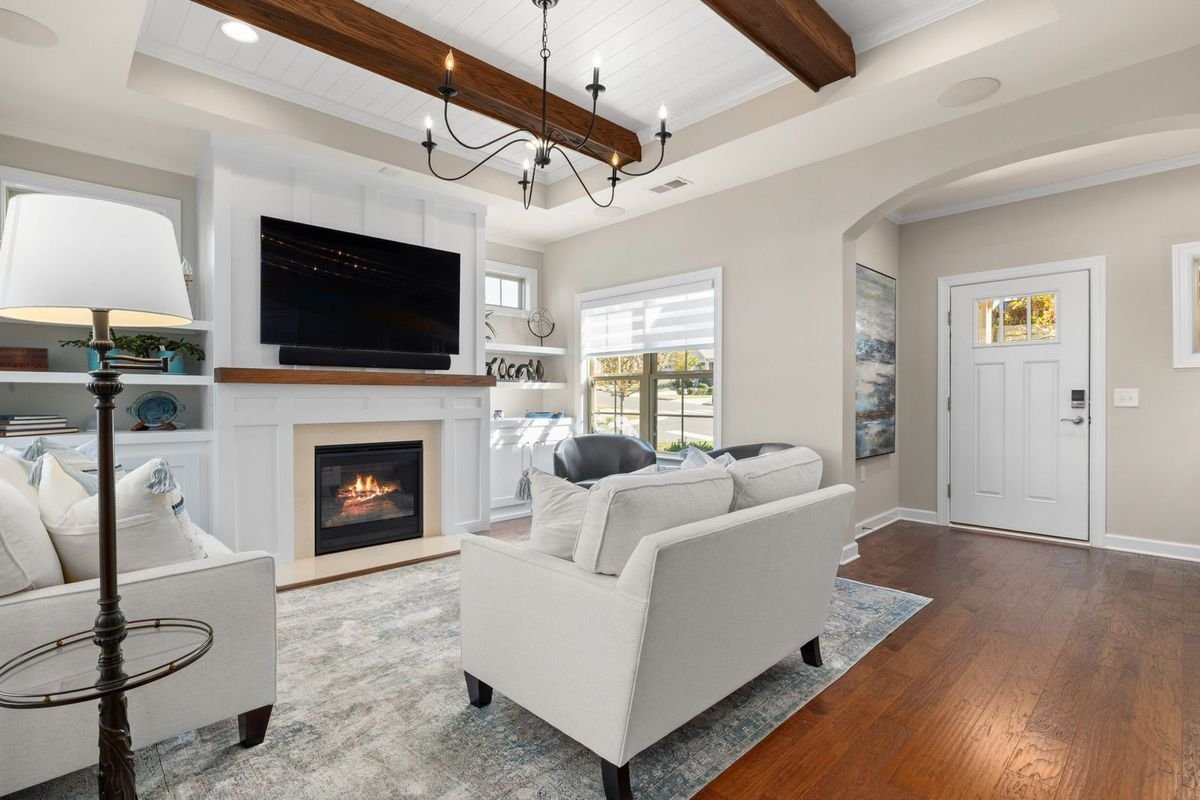 Living room with a fireplace and large TV beside white sofas (representative photo, not the exact product)