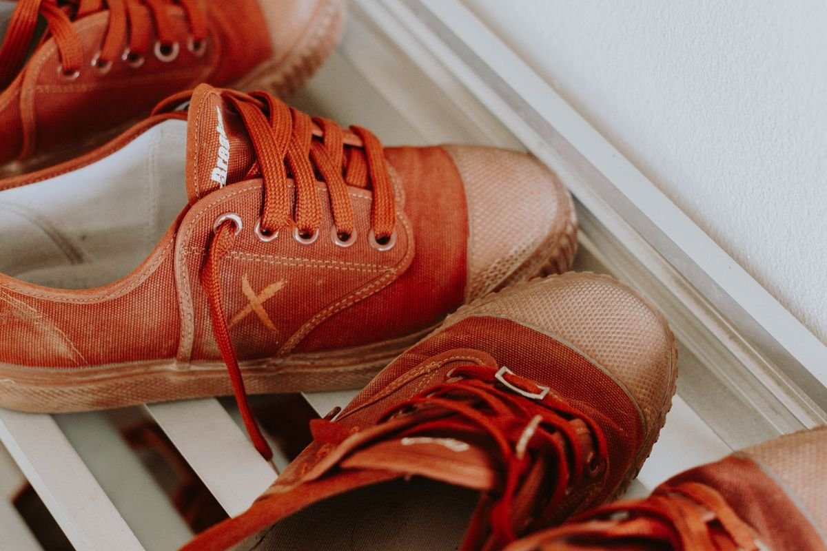 Red sneakers on a white slatted shoe rack (representative photo, not the exact product)