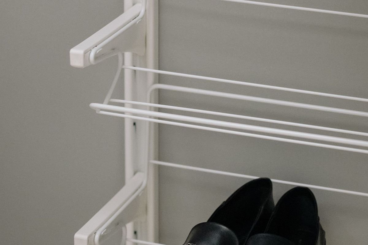 Black shoes on a white wire shoe rack (representative photo, not the exact product)