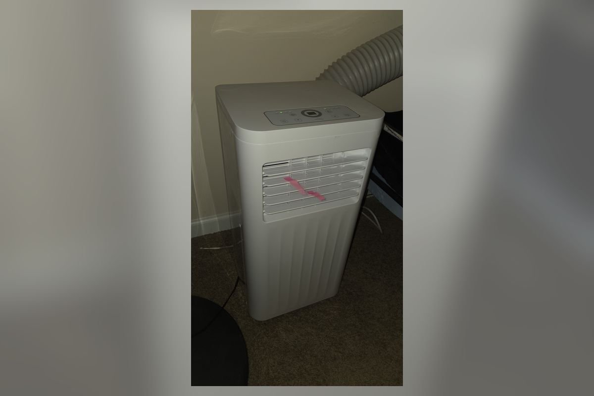 White portable air conditioner standing in a room (representative photo, not the exact product)